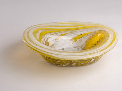 An oval, hand blown, glass vessel - yellow with white stripes