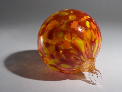 An orange, red and yellow ornament made of blown glass